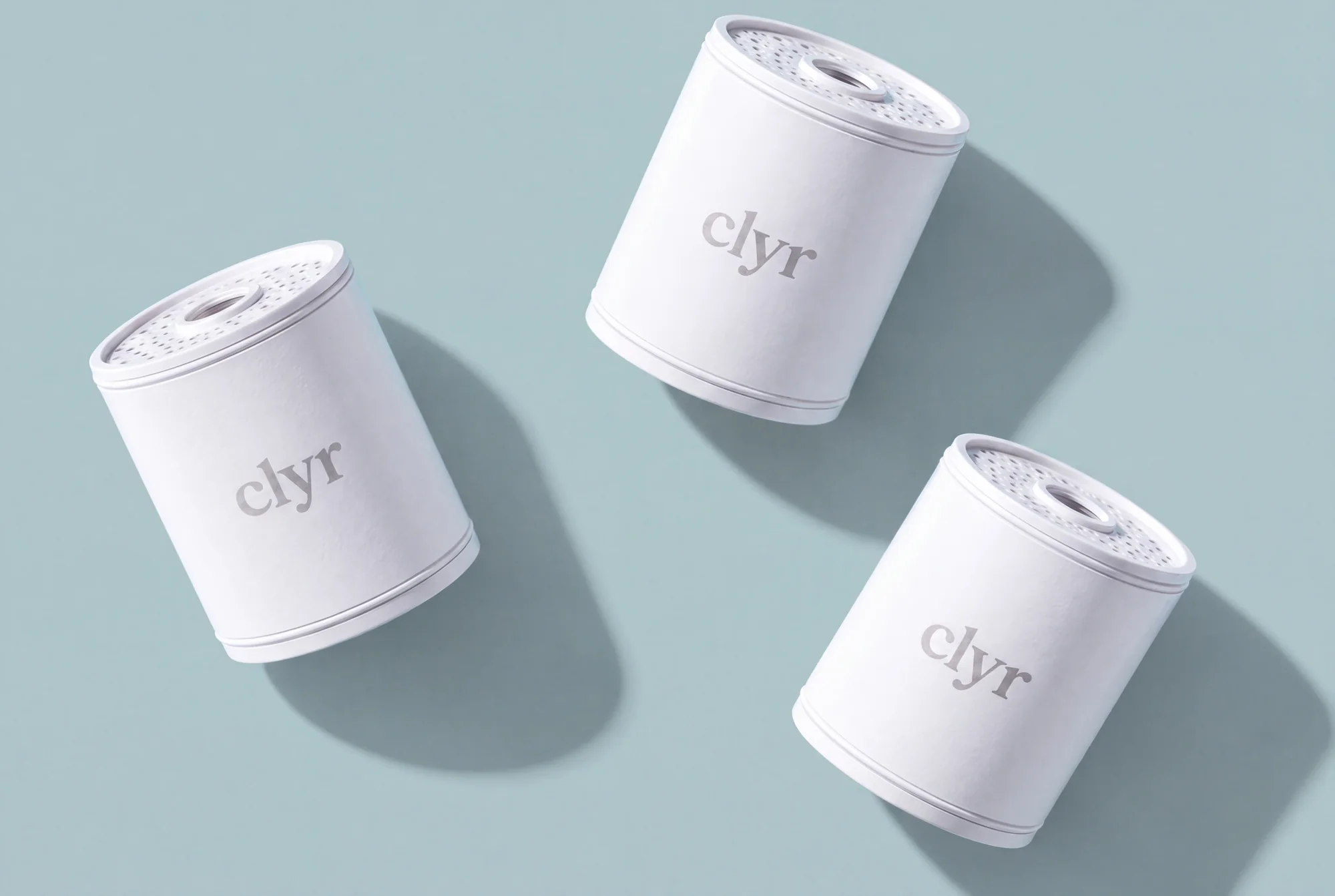 Three replaceable Clyr filter cartridges on a mineral background