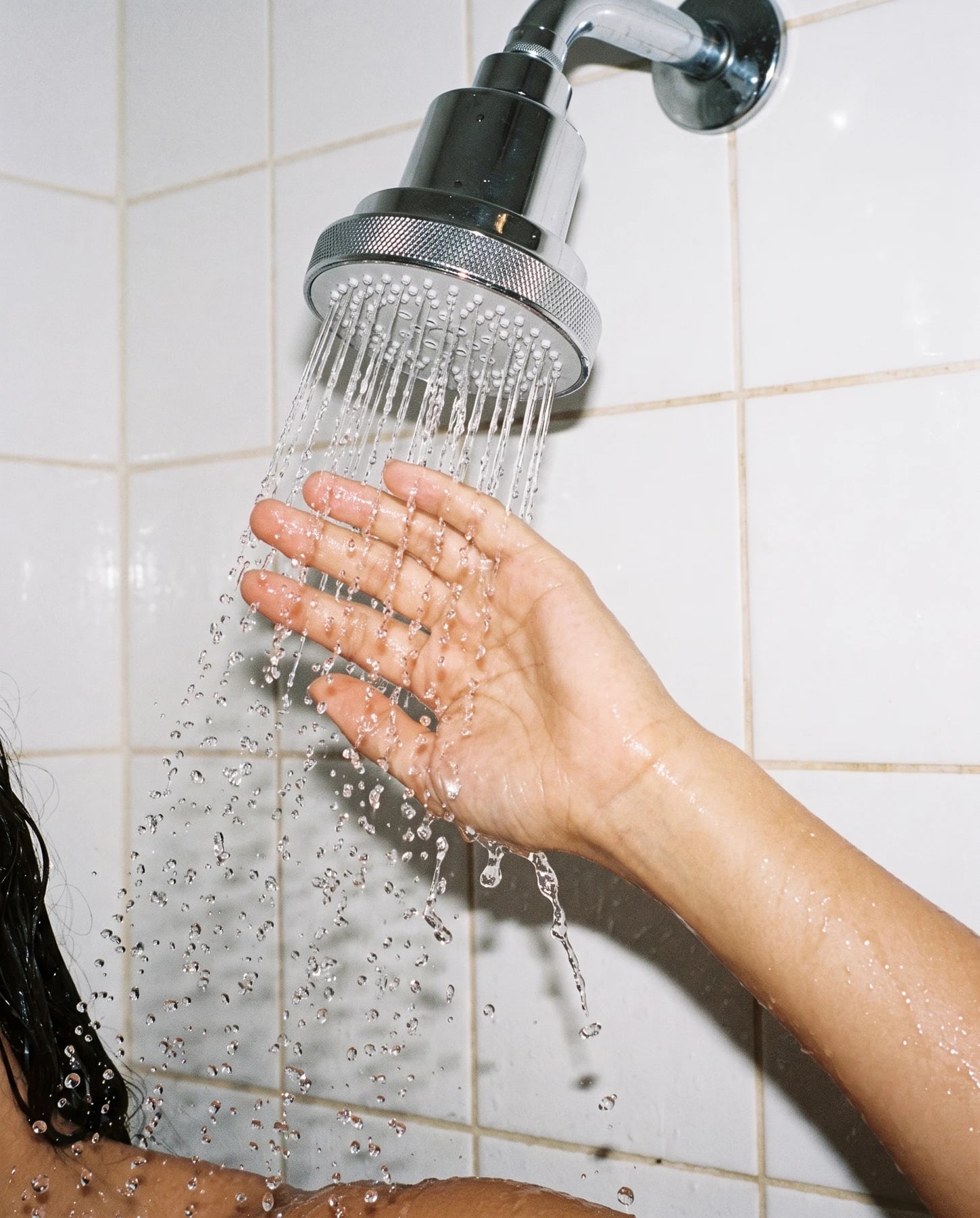 Water flowing through an installed matte black Clyr showerhead