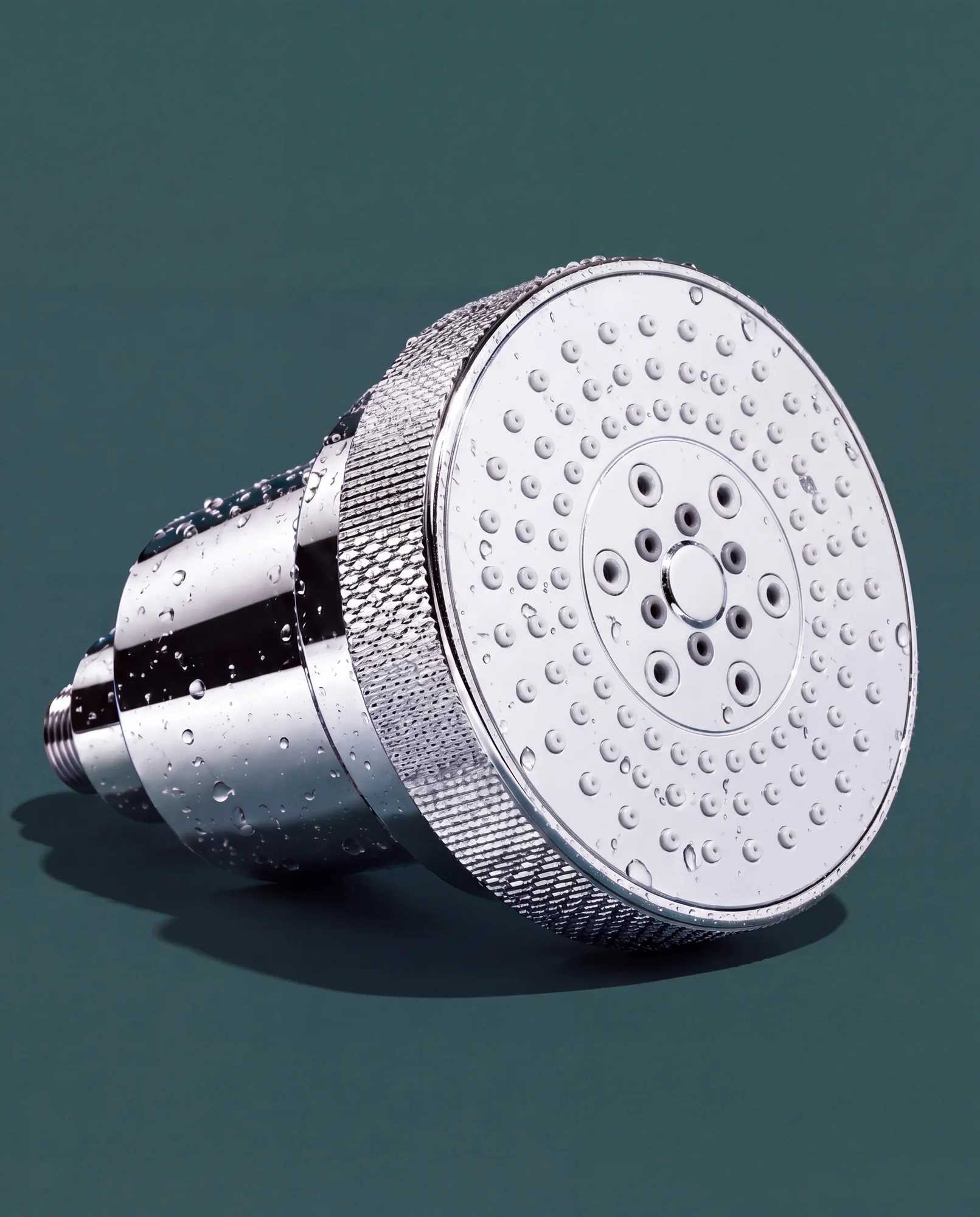 Chrome Clyr filtered showerhead on a deep teal background